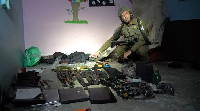 Israeli military spokesperson Rear Admiral Daniel Hagari shows what he says are weapons stored by Hamas in the basement of Rantissi Hospital, a paediatric hospital with a specialty in treating cancer patients, at a location given as Gaza, in this still image taken from video released November 13, 2023. Israel Defense Forces/Handout via REUTERS