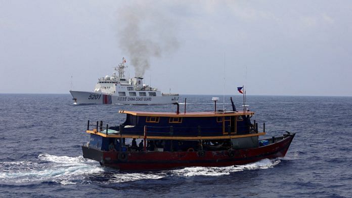 A Philippine supply boat sails near a Chinese Coast Guard ship during a resupply mission for Filipino troops stationed at a grounded warship in the South China Sea | Reuters