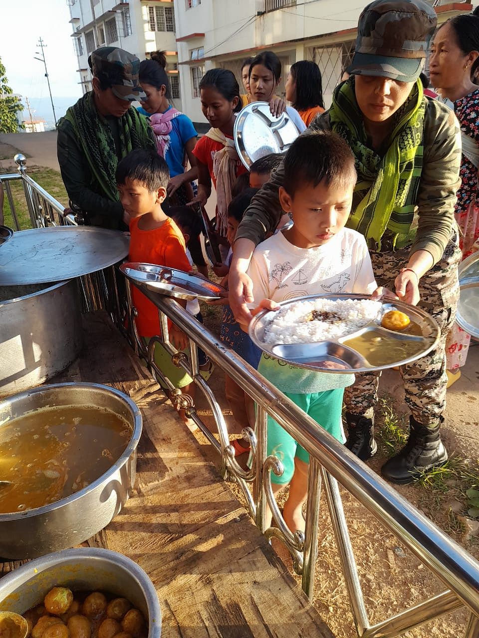 Residents being served food outside an Assam Rifles company base in Moreh | By special arrangement