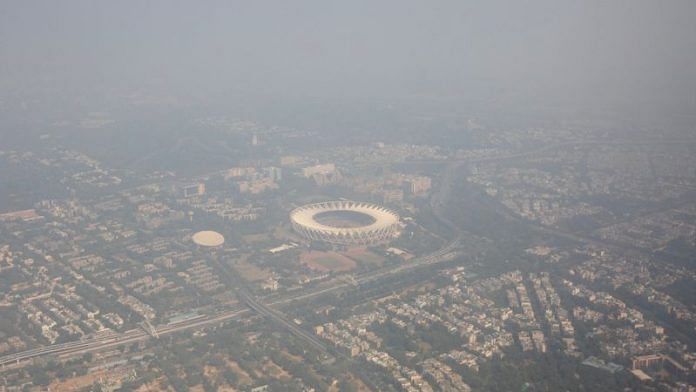 An aerial view shows residential buildings and a stadium shrouded in smog in New Delhi | Reuters