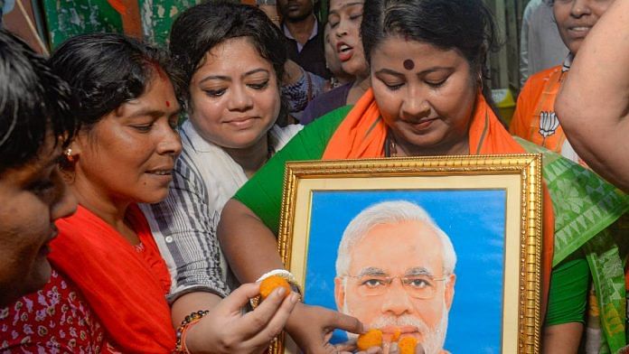 File photo of BJP Mahila Morcha members offering sweets to a photo of PM Narendra Modi to celebrate the passing of the women's reservation bill | Photo: ANI