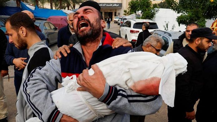 A Palestinian man reacts as he carries the body of his niece Hanan Kaloob, who was killed in an Israeli strike, at Nasser hospital in Khan Younis in the southern Gaza Strip, on 22 Nov 2023 | Reuters