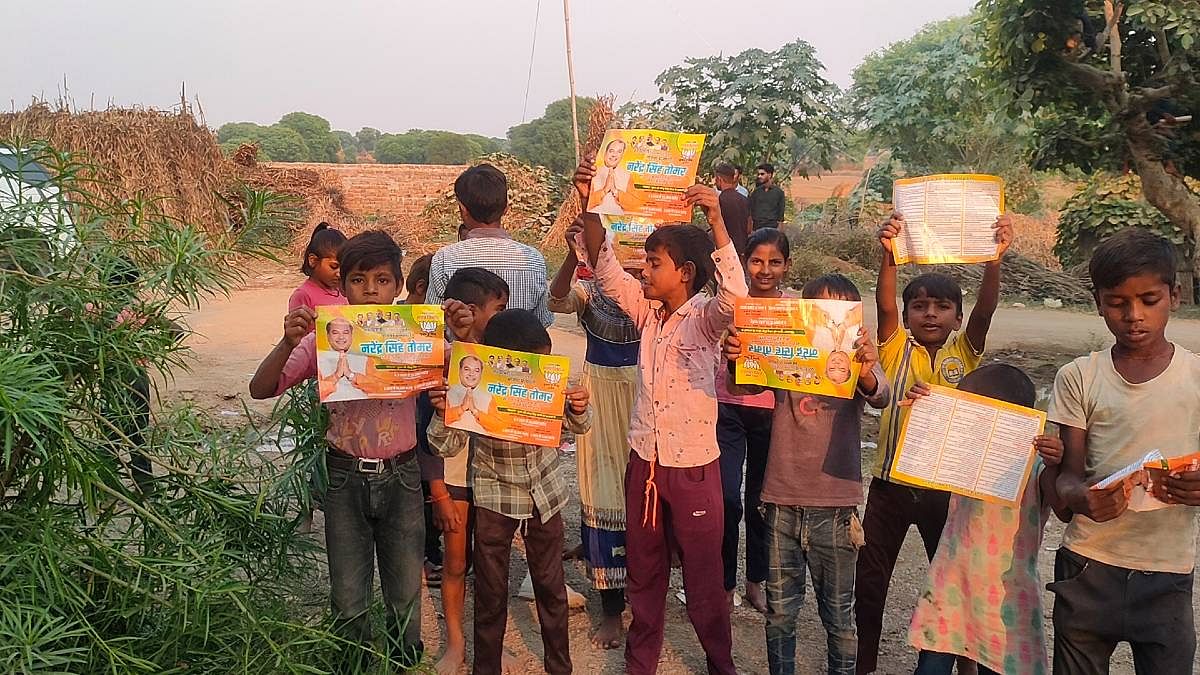Children holding candy & posters of Narendra Singh Tomar, distributed by his son while campaigning in Dimani | Iram Siddique | ThePrint
