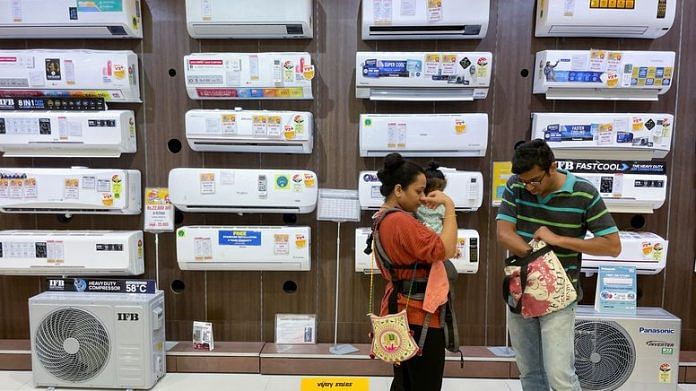 People shop for an air conditioner inside an electronics store in Mumbai | Reuters