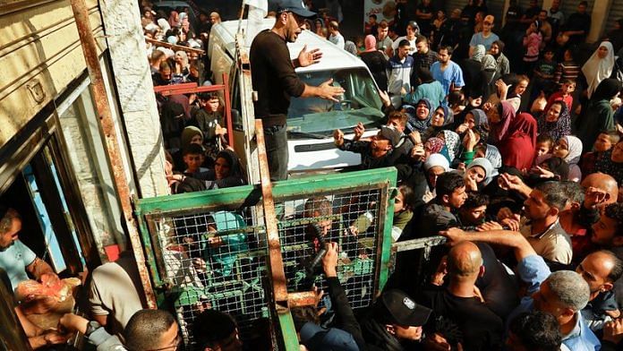 Palestinians queue as they wait to buy bread from a bakery, amid shortages of food supplies and fuel, as the conflict between Israel and Palestinian Islamist group Hamas continues, in Khan Younis in the southern Gaza Strip on 17 November, 2023 | REUTERS/Ibraheem Abu Mustafa