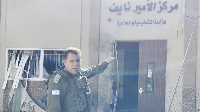An Israeli officer points at hospital signage at the Al Shifa hospital complex, amid their ground operation against Palestinian Islamist group Hamas, in Gaza, on 15 Nov 2023 | Israeli Army/Handout via Reuters
