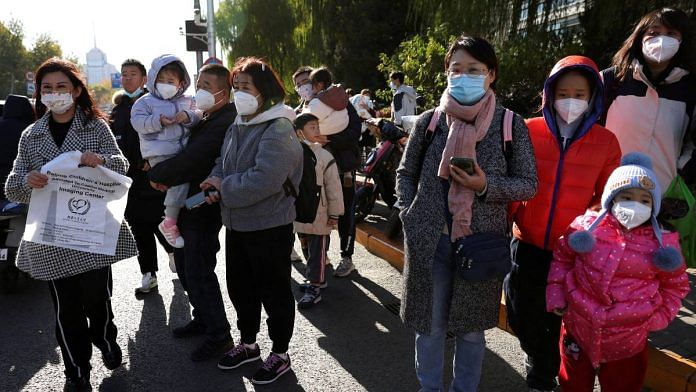 People wait for their rides outside a children's hospital in Beijing, China | Reuters