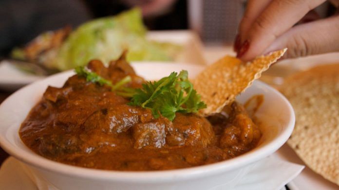 The image used in the wikipedia article of Rogan Josh. It indicates that the curry in the image is a commercial modification and that the papad “signifies non-Kashmiri preparation” | Commons