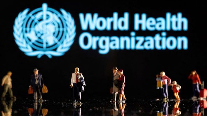 Small figurines are seen in front of the displayed World Health Organization logo in this illustration | Reuters