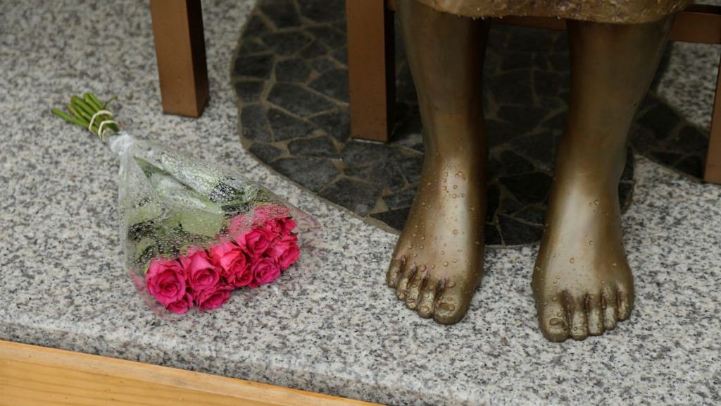 A bouquet lays alongside a statue commemorating Korean "comfort women" at a Sydney church in Sydney, Australia December 15, 2016, a 1.5-metre statue imported from Korea which has been a flashpoint for tensions between Korean and Japanese communities in Sydney since it was unveiled in August. REUTERS/Jason Reed/File Photo