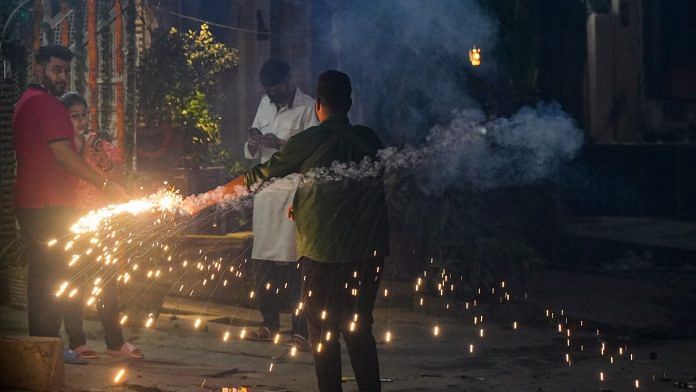People burst firecrackers to celebrate the Diwali festival, in New Delhi, on 12 Nov 2023 | PTI photo