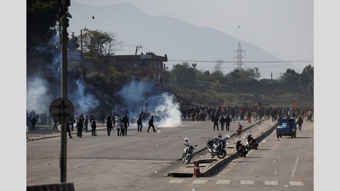 Pro-monarchist protesters run for cover as riot police personnel lobbed tear gas shells to disperse the crowd during the protest demanding the restoration of Nepal's monarchy, which was abolished in 2008, saying the governments have failed to make any significant changes in Kathmandu, Nepal November 23, 2023. REUTERS/Navesh Chitrakar