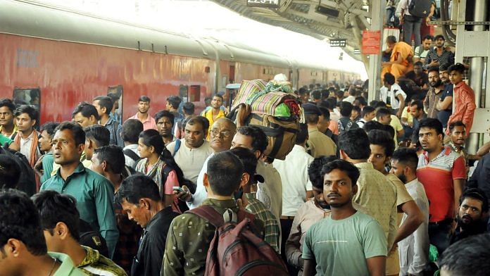 Passengers rush to board a crowded train to travel to their hometown on the eve of the Diwali festival, in Surat on Saturday | Photo: ANI