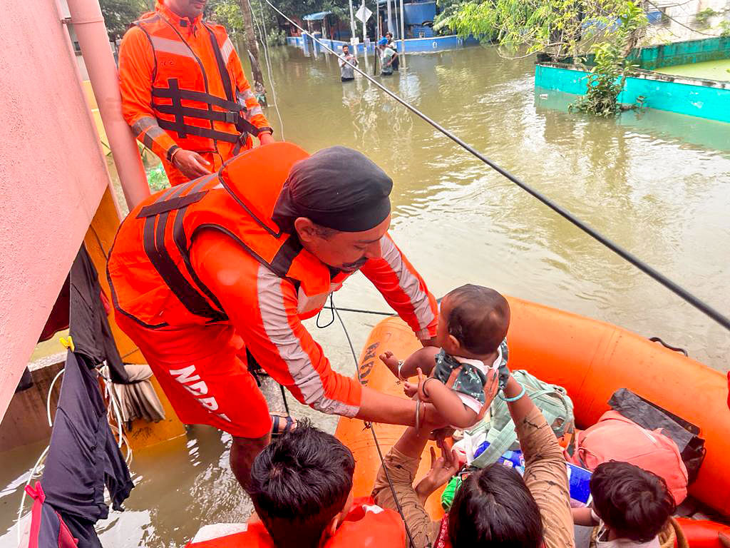 National Disaster Response Force (NDRF) personnel rescue people from the waterlogged areas of the Varadharajapuram area following heavy rainfall, in Chennai on Tuesday | ANI