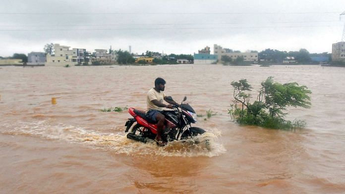A commuter on a road waterlogged due to heavy rain owing to Cyclone Michaung, in Nellore, Andhra Pradesh, Monday, Dec. 4, 2023. (PTI Photo)