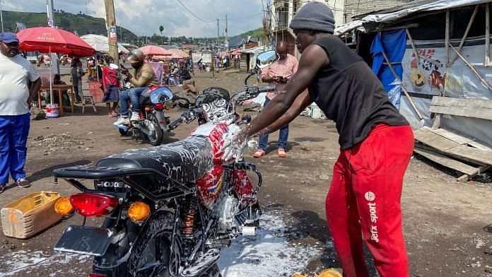 Ishara Bahati Yassin, 20, an internally displaced Congolese from Kibumba, works at his motorbike washing bay business, in Munigi, near Goma, North Kivu province of the Democratic Republic of Congo, December 7, 2023. REUTERS/Djaffar Sabiti