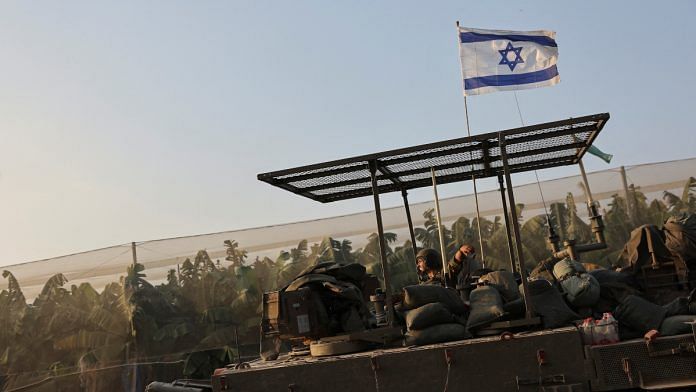 An Israeli soldier rides in an armoured personnel carrier (APC), amid the conflict between Israel and the Palestinian Islamist group Hamas, near the Israel-Gaza border, in southern Israel, December 25, 2023 | Reuters