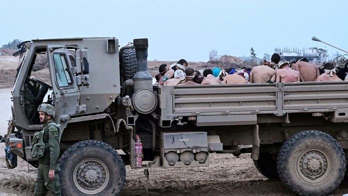 An Israeli soldier stands next to a truck with Palestinian detainees in the Gaza Strip | Reuters