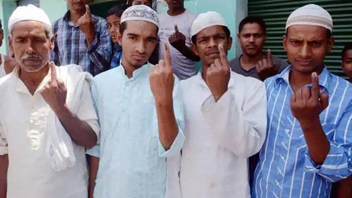 A photo of four Muslim men of varying ages showing their inked fingers, indicating they have voted.