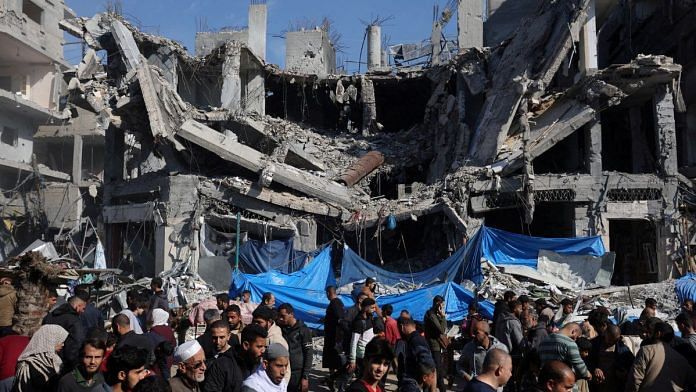 Palestinians shop in an open-air market near the ruins of houses and buildings destroyed in Israeli strikes during the temporary truce between Hamas and Israel | Representational image | Reuters