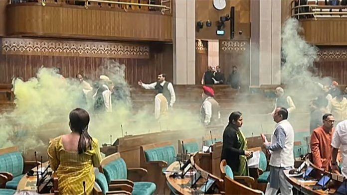 A video grab taken from the India TV channel shows an unidentified man jumping from the visitor's gallery of Lok Sabha, causing a scene using a colour smoke in the House during the Winter Session of Parliament, in New Delhi on Wednesday. (ANI Photo/India TV)