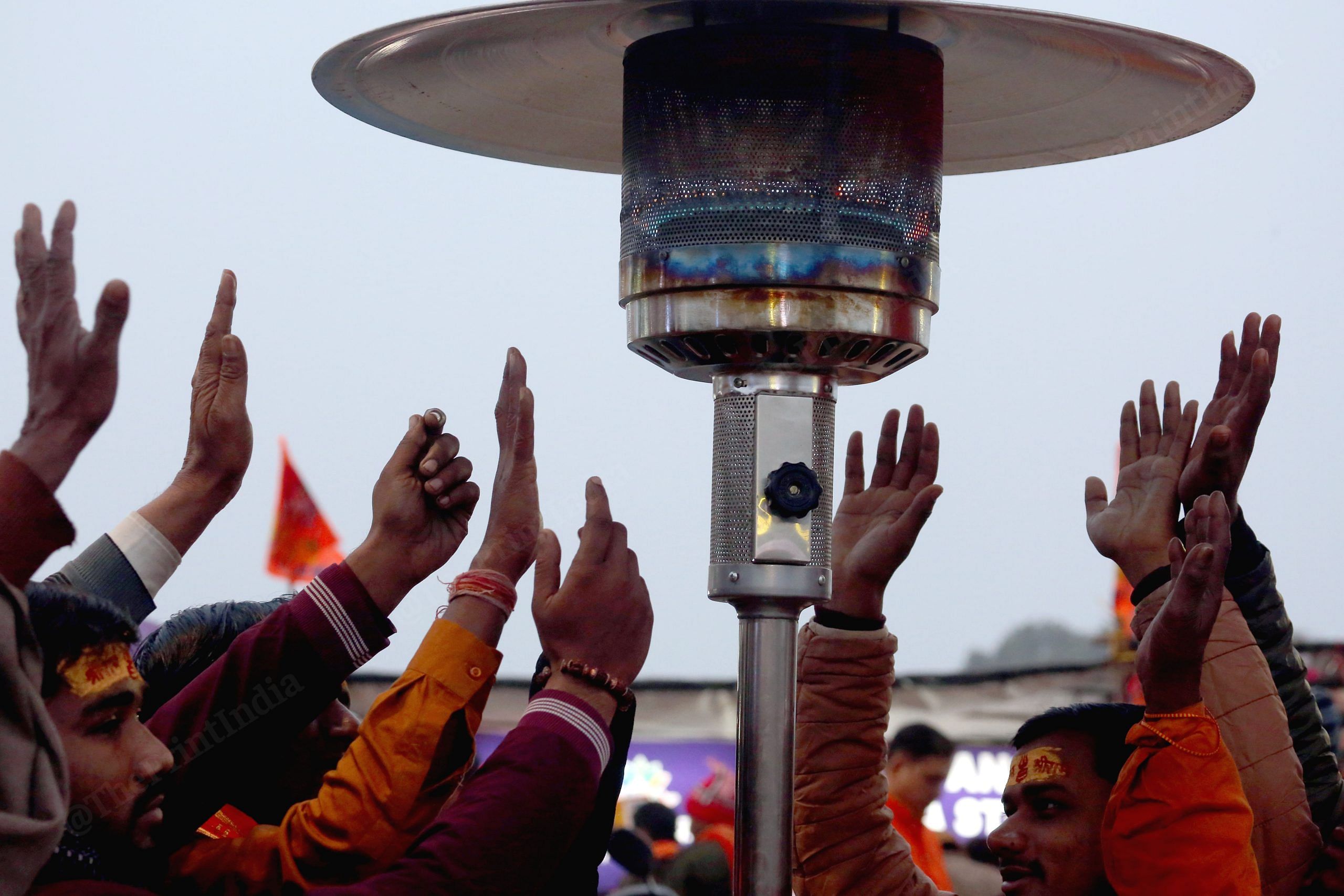 Devotees stand under heater installed near Lata Mangeshkar Chowk | Praveen Jain | ThePrint