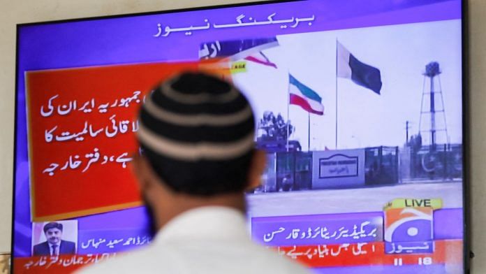 A man looks at a TV screen after the Pakistani foreign ministry said the country conducted strikes inside Iran targeting separatist militants, two days after Tehran said it attacked Israel-linked militant bases inside in Karachi, on 18 Jan 2023 | Reuters