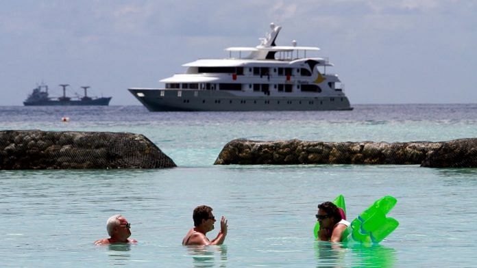 Tourists enjoy the sea as a safari boat sails past, near Vihamanafushi island, Maldives | Reuters file photo