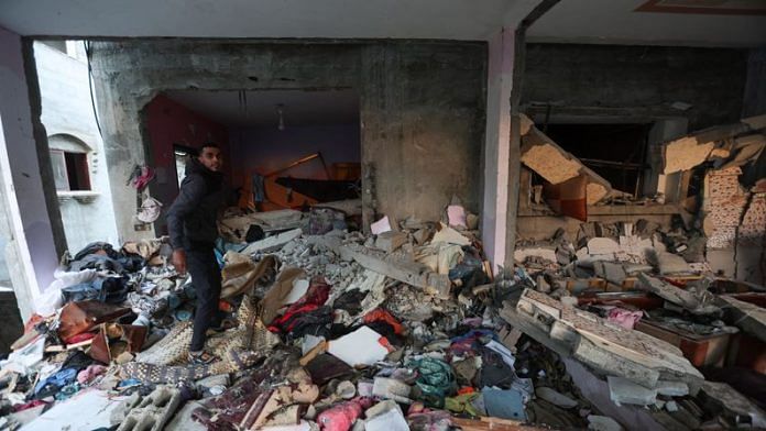 A Palestinian man inspects a house damaged in an Israeli strike in the southern Gaza Strip, on 5 Jan 2024 | Reuters