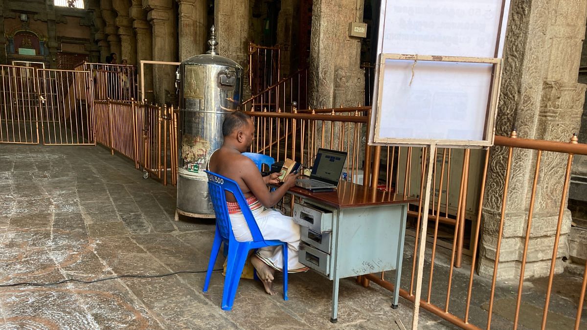 A temple priest monitors donations on his laptop | Vandana Menon | ThePrint