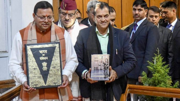 File photo of Uttarakhand Chief Minister Pushkar Singh Dhami holding the Constitution as he arrives at the assembly to table the Uniform Civil Code Bill | ANI
