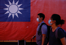 Representational photo of people walking past a Taiwan flag in Taipei, Taiwan | Reuters 