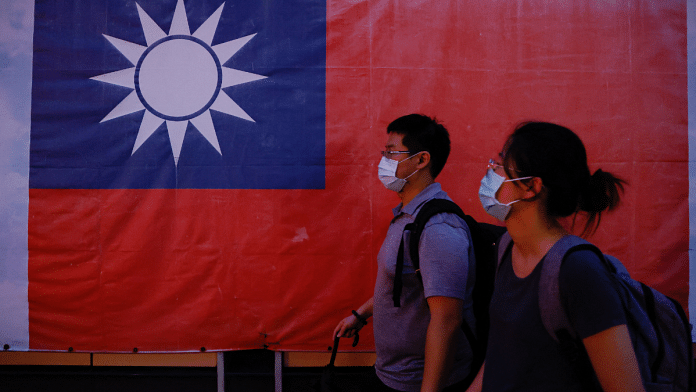 Representational photo of people walking past a Taiwan flag in Taipei, Taiwan | Reuters 
