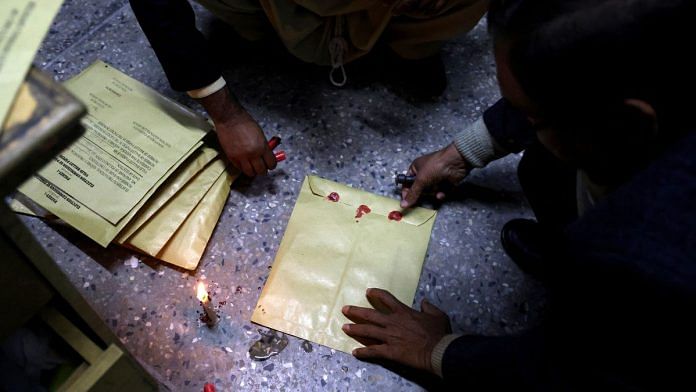 Workers seal election papers with wax at a polling station, in Islamabad, Pakistan, February 8, 2024 | Reuters/Gabrielle Fonseca Johnson
