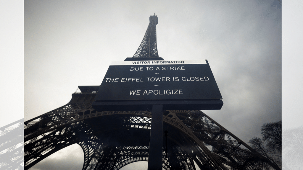 A sign reading "Due to a strike, the Eiffel Tower is closed. We apoligize" hangs in front of the Eiffel Tower in Paris | Sarah Meyssonnier | Reuters
