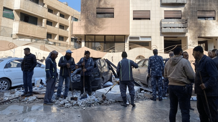 Workers and people stand near a damaged building after, according to Syrian state media reports, several Israeli missiles hit a residential building in the Kafr Sousa district, Damascus, Syria February 21, 2024 | Firas Makdesi | Reuters