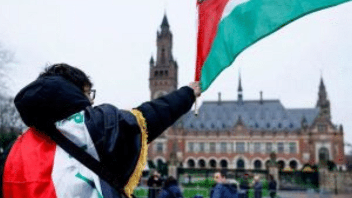 A man waves a Palestinian flag as people protest on the day of a public hearing held by The International Court of Justice (ICJ) to allow parties to give their views on the legal consequences of Israel's occupation of Palestinian territories. Piroschka van de Wouw | File Photo | Reuters