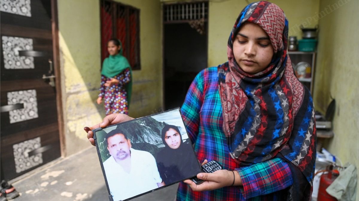 Qasim's daughter Nisha holds up a picture of her parents | Suraj Singh Bisht | ThePrint