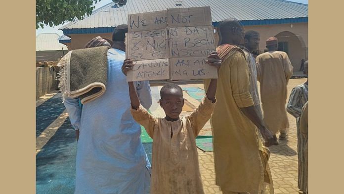 A boy holds a sign to protest against, what a teacher, local councilor and parents said, the kidnapping of hundreds school pupils by gunmen after the Friday prayer in Kaduna, Nigeria March 8, 2024 | Reuters/Stringer/File Photo
