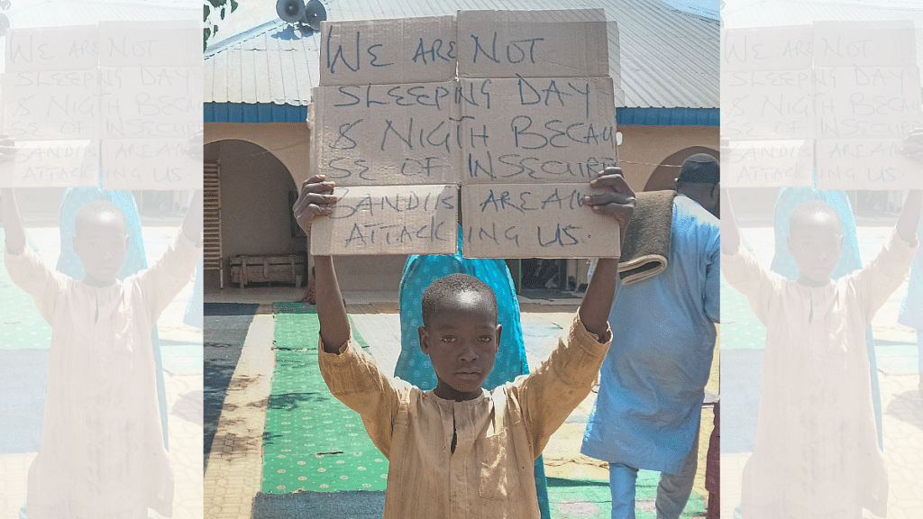 A boy holds a sign to protest against kidnapping of hundreds school pupils by gunmen on 8th March | Representative image | Reuters