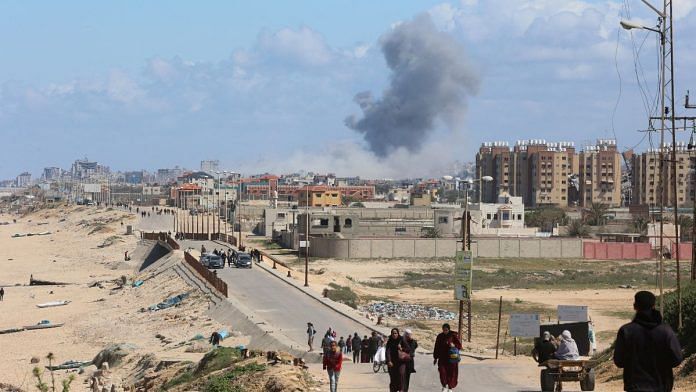 Smoke rises following an Israeli strike. Palestinians fleeing north Gaza due to Israel’s military offensive move southward, amid the ongoing conflict between Israel and Hamas, at the central Gaza Strip, March 15, 2024 | Representative image | Reuters/Ahmed Zakot