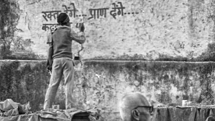 On 5 December 1992, a kar sevak writes ‘Rakt denge, pran denge’ (we will give blood, we will give our lives) on a wall, a day before the demolition of the Babri Masjid | Photo: Praveen Jain | ThePrint