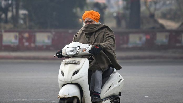 A man on his two-wheeler on a cold winter day in New Delhi | Photo: ANI Photo/Ishant