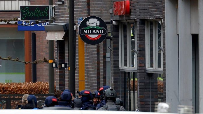 Dutch police officers stand near the Cafe Petticoat, where several people are being held hostage in Ede, Netherlands March 30, 2024 | Reuters