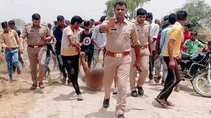 File photo of police escorting men dragging Qasim in Hapur, Uttar Pradesh, on 18 June 2023. | PTI