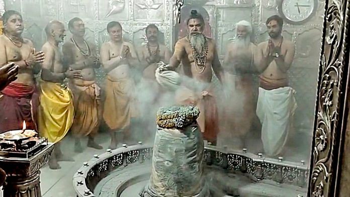 A priest performs abhishek on Shiva Linga during the 'Phoolon Wali Holi' celebrations at Mahakaleshwar Temple, in Ujjain on Sunday, 24 March 2024 | ANI