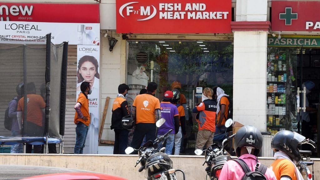 File photo of Swiggy workers waiting to collect orders in Gurugram. | ANI
