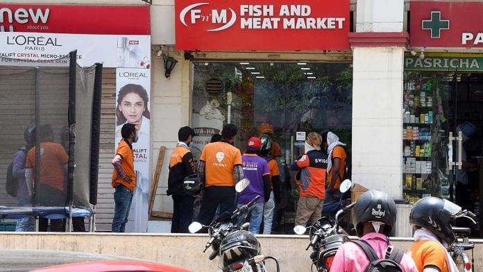 File photo of Swiggy workers waiting to collect orders in Gurugram. | ANI