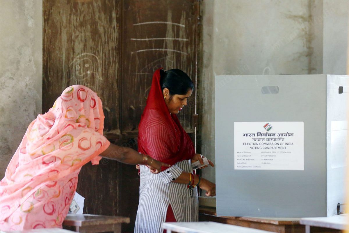 A woman stands near EVM in one of the polling booths in Jewar | Praveen Jain | ThePrint