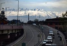 Vehicles ply on the road against the backdrop of snow-capped mountains in Srinagar | Photo: ANI/Imran Nissar